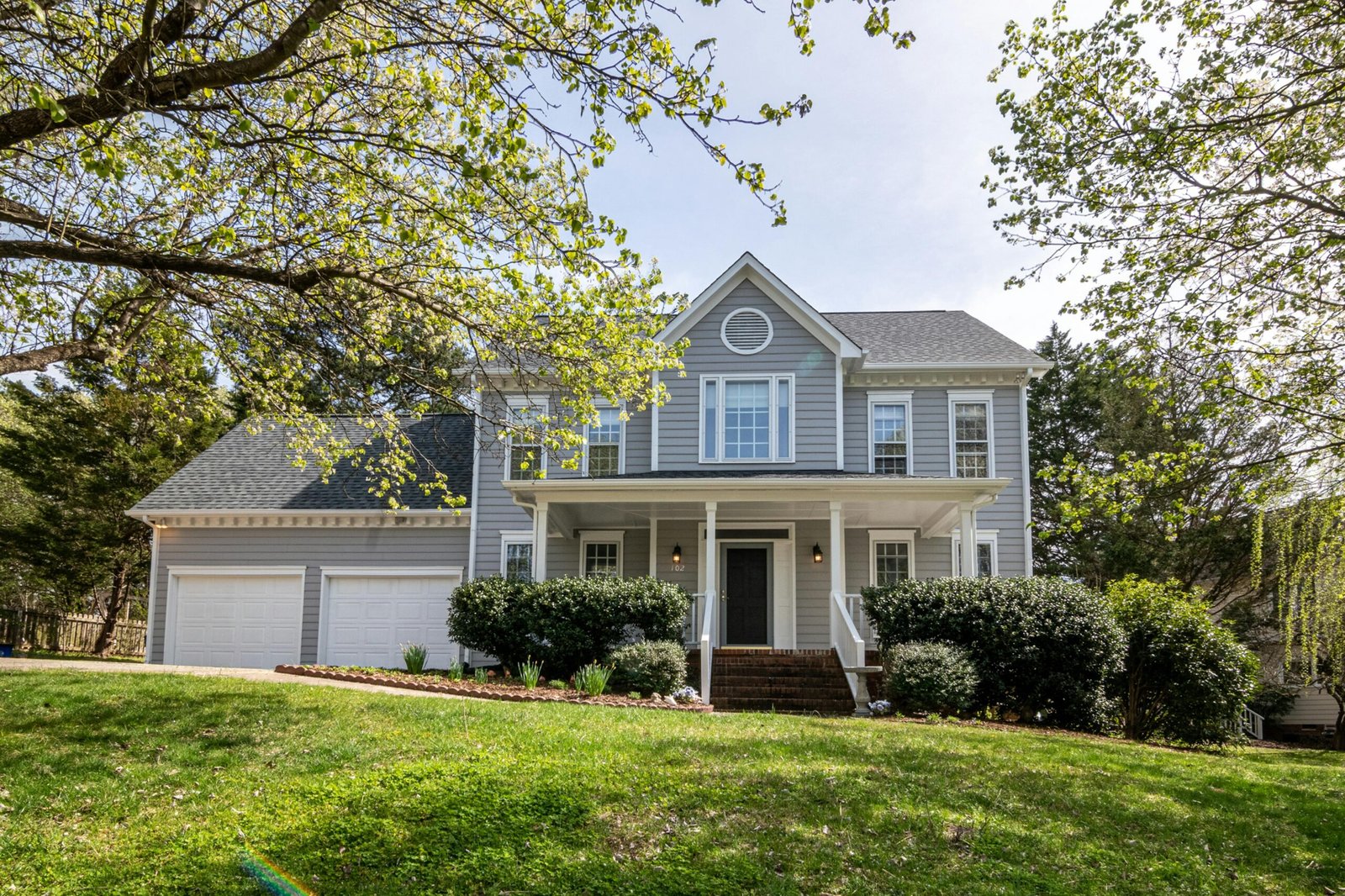 A beautiful suburban house surrounded by trees and lush greenery, perfect for families.